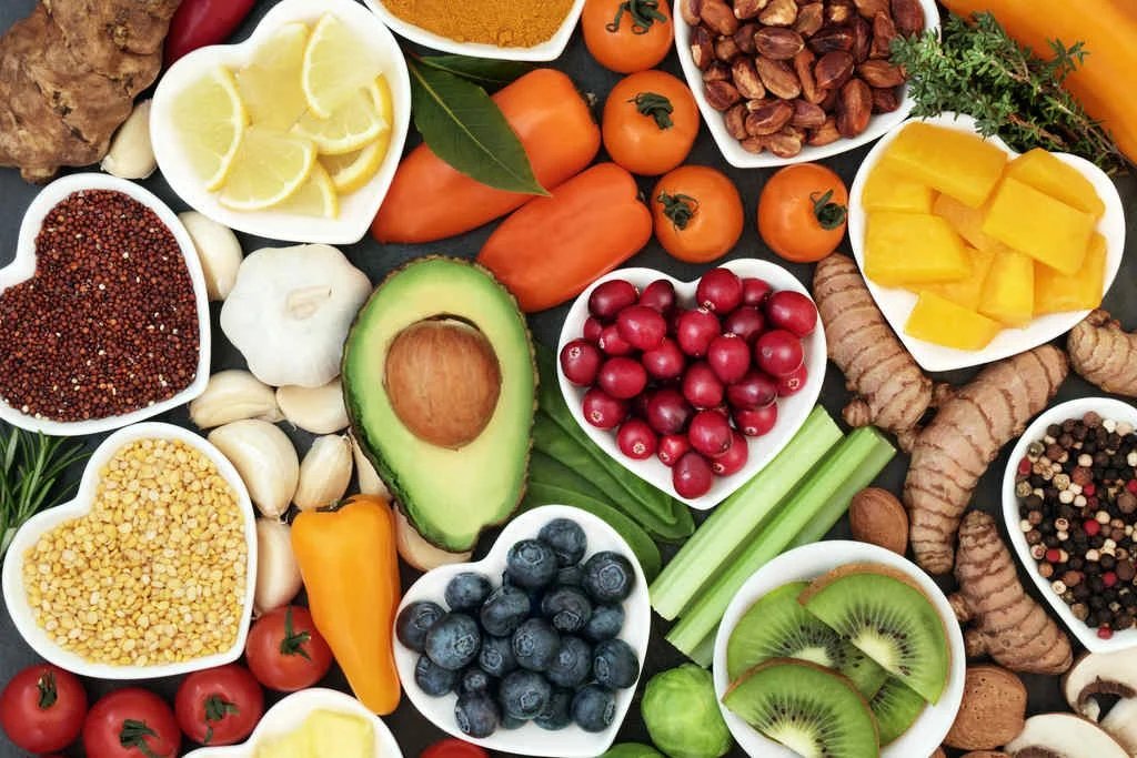 Alimentos in natura em potes de coração: frutas vermelhas, abacate, gengibre e sementes